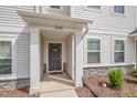 Welcoming front door with decorative wreath and stone accents around the base of the covered entryway at 2708 Chert Ln, Raleigh, NC 27610