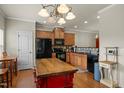 The kitchen has wooden cabinets, a black appliance package, and a functional island at 276 Linden Park Ln, Cary, NC 27519