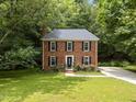 Beautiful two-story brick home with a manicured front lawn, black shutters and a tree-lined lot at 308 Trappers Sack Rd, Cary, NC 27513