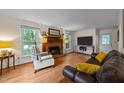Inviting living room with a traditional brick fireplace, hardwood floors and large windows at 308 Trappers Sack Rd, Cary, NC 27513