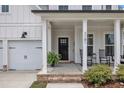Inviting front porch featuring rocking chairs and a hanging plant by the front door at 3181 Zebroid Way, New Hill, NC 27562