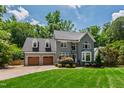 Beautiful two-story gray house with attached garage, lush green lawn, and well-maintained landscaping at 3304 Buck Run Trl, Wake Forest, NC 27587