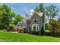 Attractive gray two-story home surrounded by lush greenery with a two-car garage on a sunny day at 3304 Buck Run Trl, Wake Forest, NC 27587