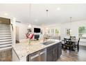 Open-concept kitchen with granite countertops, stainless steel appliances, and seamless flow to living area at 3361 Bordwell Ridge Dr. Dr, New Hill, NC 27562