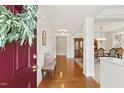 Inviting home foyer with hardwood floors, an entry bench, and views into the dining room with classic furnishings at 400 Indian Elm Ln, Cary, NC 27519