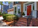 Close-up of a charming red front door with brick steps and decorative landscaping at 405 Widdington Ln, Cary, NC 27519
