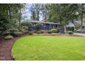 Charming blue home with mature trees, green lawn, and beautiful landscaping at 418 Ridgefield Rd, Chapel Hill, NC 27517