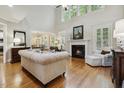 Bright and airy living room featuring a fireplace, hardwood floors, and large windows for natural light at 4221 Bibleway Ct, Holly Springs, NC 27540