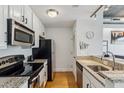 Galley kitchen with stainless steel appliances, granite counters, and modern finishes at 444 S Blount St # 209, Raleigh, NC 27601
