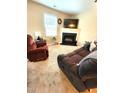 Carpeted living room with fireplace, TV, sofa, and large window at 5126 Thornton Knoll Way, Raleigh, NC 27616