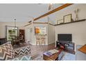 Inviting living room with vaulted ceilings, wood beams, stylish furniture, and an open view to the dining area at 5801 Hadrian Dr, Durham, NC 27703