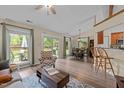 Bright, open-concept living area featuring wood floors, large windows and sliding glass doors to the backyard at 5801 Hadrian Dr, Durham, NC 27703