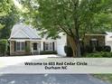 Well-maintained home with lush landscaping, mature trees, and a long driveway at 603 Red Cedar Cir, Durham, NC 27712