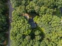 Aerial view of a secluded home surrounded by lush greenery, offering privacy and a peaceful setting at 6817 Guess Rd, Hillsborough, NC 27278