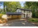 Traditional white brick home featuring a convenient carport and well-manicured front yard, surrounded by mature trees at 6817 Guess Rd, Hillsborough, NC 27278
