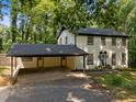 Traditional white brick home featuring a convenient carport and well-manicured front yard, surrounded by mature trees at 6817 Guess Rd, Hillsborough, NC 27278