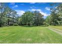 Lush green yard with mature trees and beautiful landscaping surrounds this charming home at 705 Wilsons Mills Rd, Smithfield, NC 27577