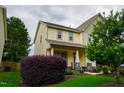 An angled view of the house showing a colorful bush and manicured front lawn at 825 Fulworth Ave, Wake Forest, NC 27587