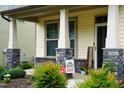 Inviting front porch with stone pillars and decorative plants and a welcome sign at 825 Fulworth Ave, Wake Forest, NC 27587