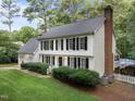 A classic white two story home shows off mature landscaping and black window shutters at 8909 Wellsley Way, Raleigh, NC 27613