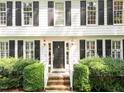 Charming front entrance with a black door and brick steps framed with shrubbery at 8909 Wellsley Way, Raleigh, NC 27613