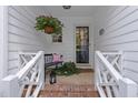 Inviting front porch with a bench, hanging flowers, and a charming welcome at 8909 Wellsley Way, Raleigh, NC 27613