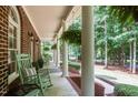Spacious front porch featuring classic rocking chairs and lush hanging plants, perfect for relaxation at 901 Tamaras Cir, Wake Forest, NC 27587