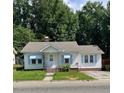 Cozy one-story home with light blue awnings, a brick chimney, and inviting front steps at 906 Camden Ave, Durham, NC 27701
