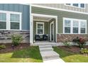 Inviting front porch with seating, landscaped garden, and a charming entryway at 937 Baldwin Ridge Rd, Apex, NC 27523