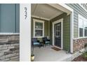 Cozy front porch with seating, a security camera, and a well-lit entryway at 937 Baldwin Ridge Rd, Apex, NC 27523