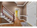 Inviting foyer features hardwood floors, a staircase with white railings, and a glimpse into an adjacent room at 1 Gatesway Ct, Durham, NC 27707