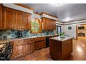 Well-lit kitchen with wood cabinets, a center island, and a view into an open-plan dining area at 1 Gatesway Ct, Durham, NC 27707
