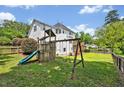 Spacious backyard featuring a play set, wooden fence, and lush green grass at 100 Highfield Ave, Cary, NC 27519