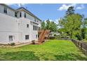 Large backyard with a wooden deck, well-maintained lawn, and privacy fence at 100 Highfield Ave, Cary, NC 27519