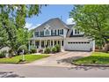 Beautiful two-story home with a covered front porch, driveway, and mature trees at 100 Highfield Ave, Cary, NC 27519