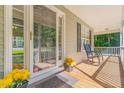 Inviting front porch featuring a rocking chair, decorative flowers, and a 