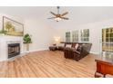 Cozy living room features a fireplace, ample natural light, vaulted ceiling, and wood laminate flooring at 101 Abram Way, Clayton, NC 27520