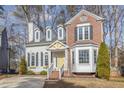 Charming two-story home featuring a mix of brick and siding, dormer windows, and a welcoming yellow front door at 112 Solstice Cir, Cary, NC 27513