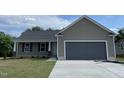 Charming single-story home featuring a covered front porch, attached two-car garage and newly paved driveway at 116 Oakfield Trace Dr, Four Oaks, NC 27524