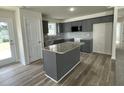 Modern kitchen with granite countertops, stainless steel appliances, a kitchen island, and gray cabinetry at 116 Oakfield Trace Dr, Four Oaks, NC 27524