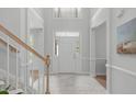 Bright foyer with high ceilings, neutral paint, tile flooring, and white front door with sidelights at 117 Drakewood Pl, Cary, NC 27518