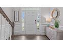 Bright foyer with wood floors, white trim and a view of the front door and stairway at 1214 Valley Dale Dr, Fuquay Varina, NC 27526