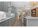 Open kitchen with gray cabinets, quartz countertops, and stainless steel appliances at 122 Glenpark Pl, Cary, NC 27511