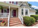 Charming front porch with brick steps and decorative shrubbery at 161 Jacob St, Holly Springs, NC 27540