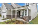 Inviting front porch with brick columns and charming seating area, perfect for relaxing at 1633 Hillstar St, Fuquay Varina, NC 27526