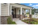 Cozy front porch with brick accents and comfortable seating, enhancing the home's curb appeal at 1633 Hillstar St, Fuquay Varina, NC 27526