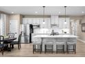 Bright kitchen featuring an island with barstool seating, stainless steel appliances, and a dining area at 196 Glen Hollow Dr, Raleigh, NC 27604