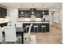 Modern kitchen with stainless steel appliances, island with seating, and dining area, perfect for entertaining at 198 Glen Hollow Dr, Raleigh, NC 27604