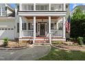 Inviting front porch showcasing decorative columns, an American flag, and freshly planted flowers at 2027 River Grove Ln, Knightdale, NC 27545