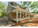 Back exterior of house with covered porch with steps and brick and grey siding at 205 Northfield Dr, Raleigh, NC 27609